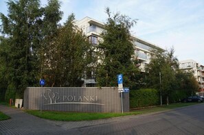 A building with a sign that reads 'POLANKI' and a parking sign indicating a parking area. - Green Dream Polanki - Sauna & Bicycle & Bicycle (Kołobrzeg)