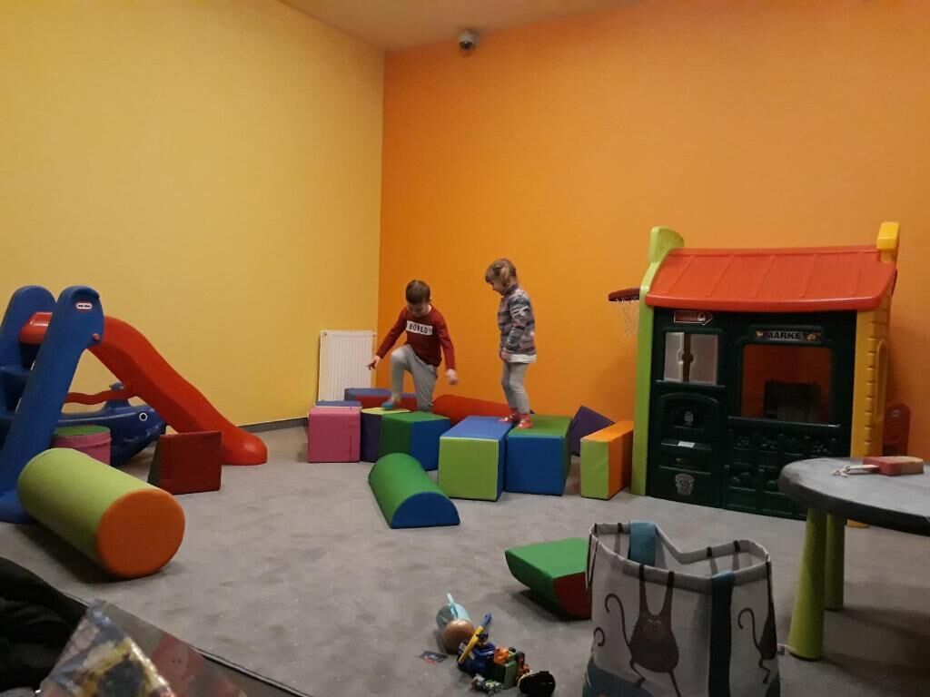 Un espace de jeux avec des blocs de couleurs vives et un toboggan.