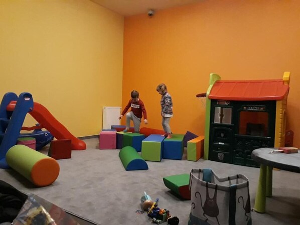 Ein Spielbereich mit bunten Bauklötzen und einer Rutsche.