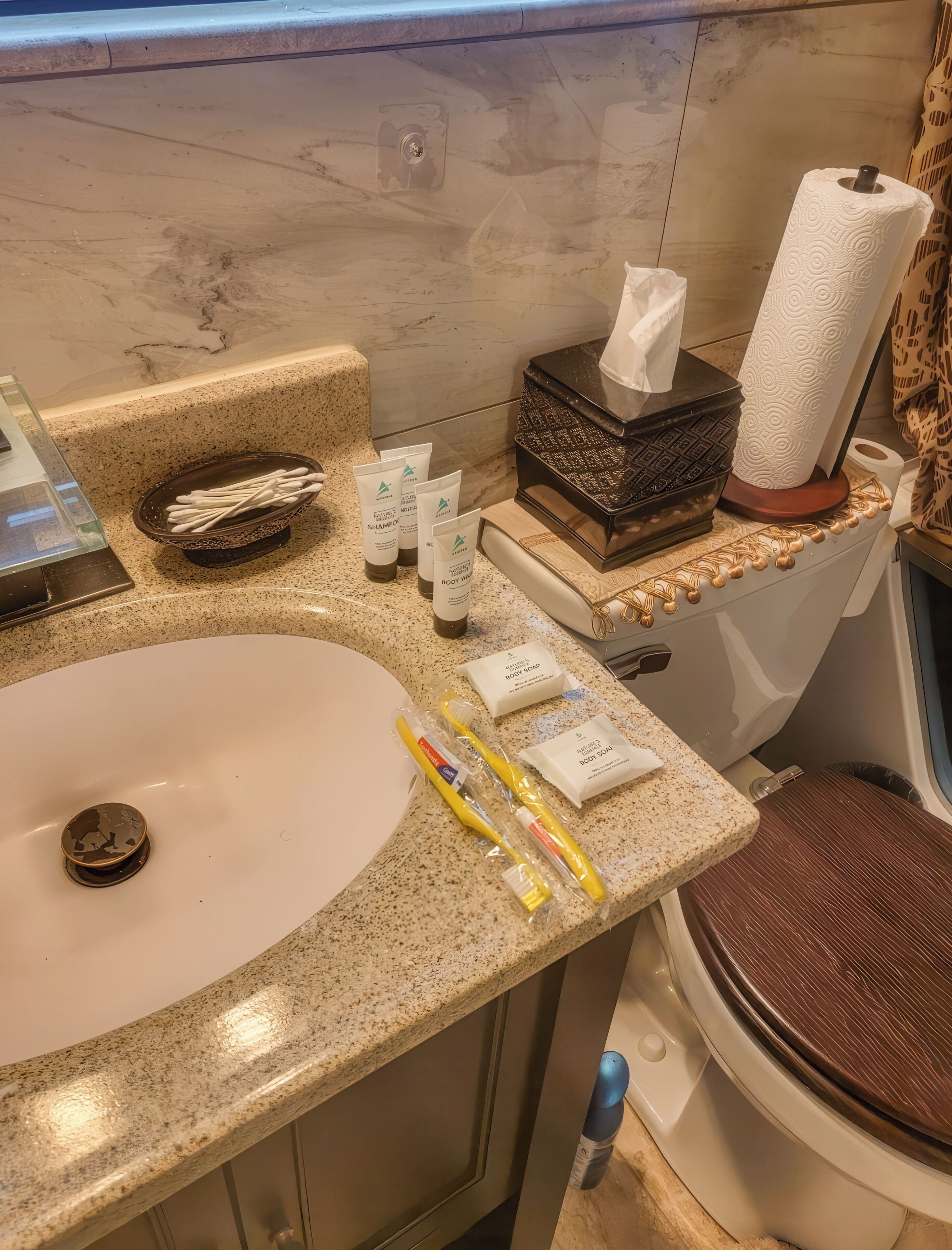A bathroom with a sink, toilet, and various toiletries.