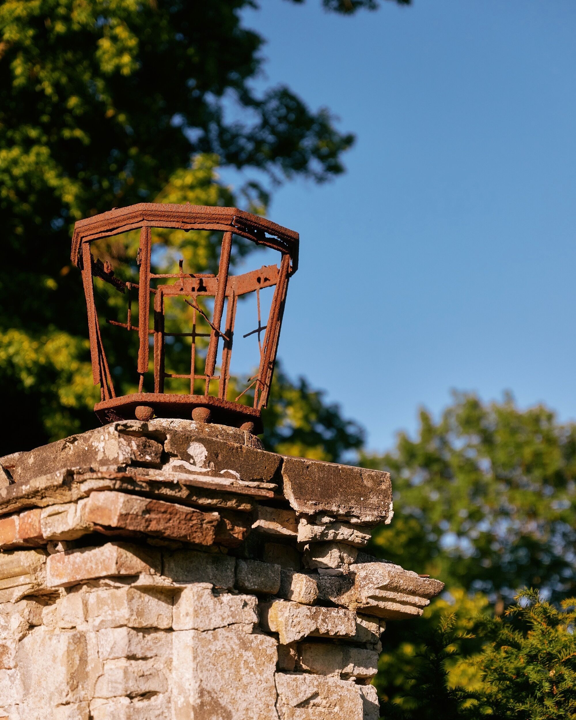 A weathered metal structure atop a stone wall.