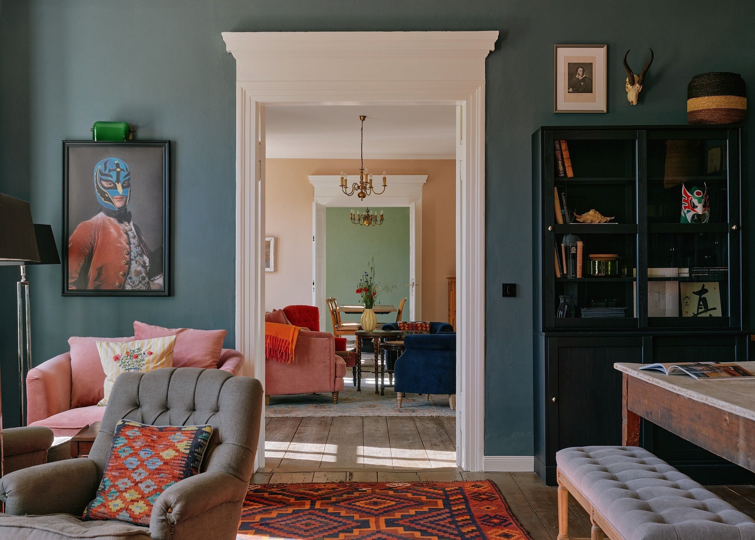 A living room with a sofa, armchair, and a dining area with a table and chairs.