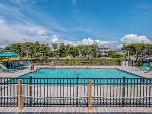 Una piscina con sillas de descanso y una terraza de madera.