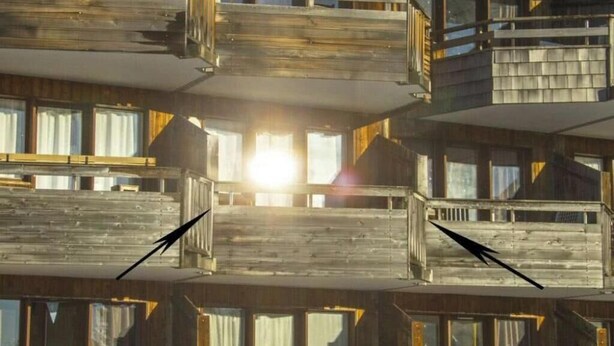 Un edificio de varios pisos con balcones y ventanas amplias.
