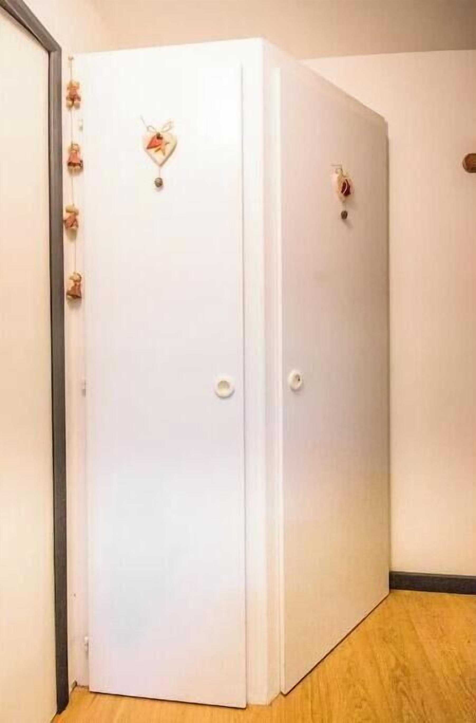 A white door with a heart-shaped decoration and a small keyhole.