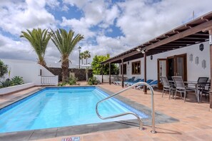 A swimming pool with a metal ladder, lounge chairs, and a pergola. - 3 Bedroom Villa with Air Conditioning, Parking and Pool (Tías)
