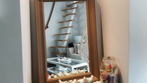 A corner with a mirror, a shelf with decorative items, and a glass jar. - Traverse du Vieux Château (Menton)