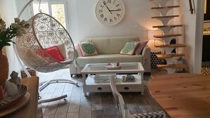A living room with a hanging chair, a sofa, a coffee table, and a staircase. - Traverse du Vieux Château (Menton)