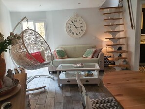 A living room with a hanging chair, a sofa, a coffee table, and a staircase. - Traverse du Vieux Château (Menton)