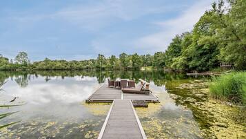 Une jetée en bois s’étendant sur un lac paisible, sous un ciel dégagé.