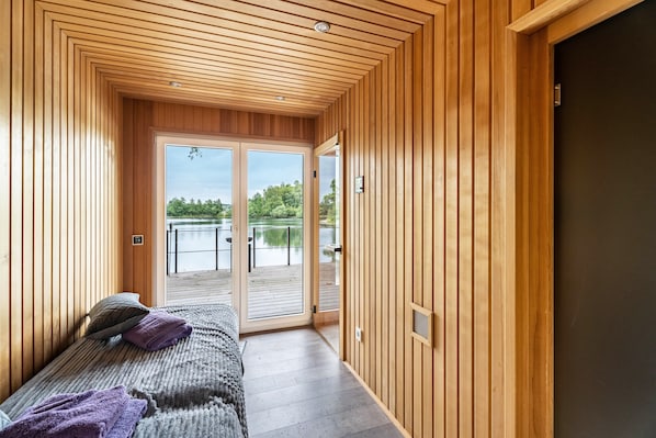 Un dormitorio con cama, ventana y vista al lago.