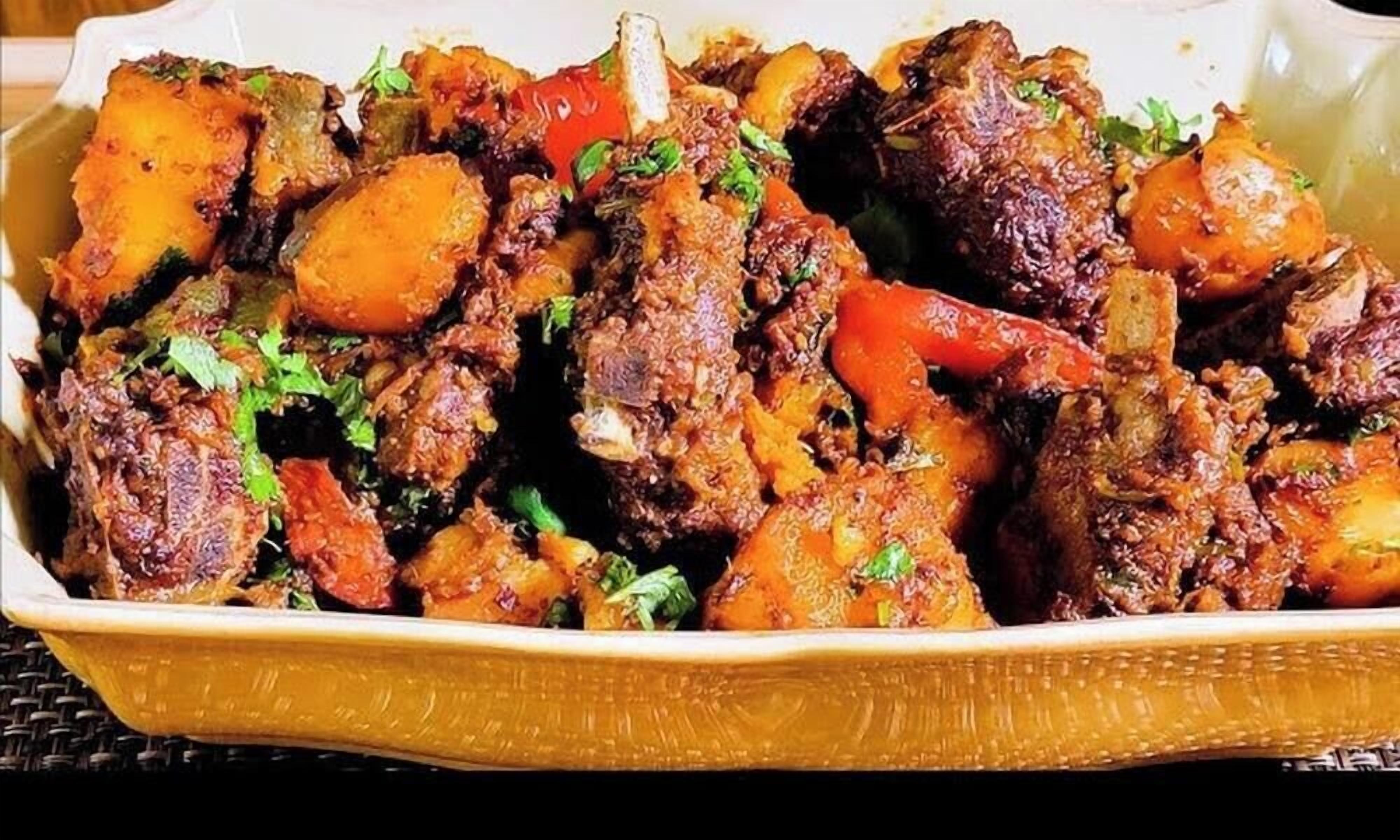 A dish with meat and vegetables in a ceramic dish.