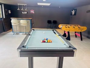 A pool table with balls, a foosball table, and a bar area with stools. - Lavender Cottage - Sleeps 12+ Hot Tub, Games Room, Pet Friendly (Burstwick)
