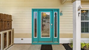 A turquoise door with a glass panel, a mailbox, and a small garden area with plants. - Pet Friendly Beach House | Walk to Beach | Sleeps 6 (Panama City Beach)