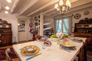 Ein Esszimmer mit einem Holztisch, gedeckt für eine Mahlzeit, umgeben von verschiedenen Tellern und Besteck.