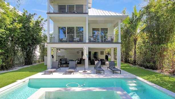 A two-story house with a swimming pool, outdoor seating, and a covered patio. - Captain's Quarters Longboat Key (Longboat Key)