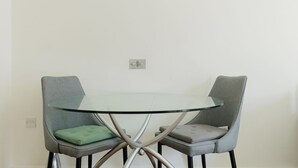 Uma mesa de jantar com duas cadeiras, cada uma com um assento almofadado.