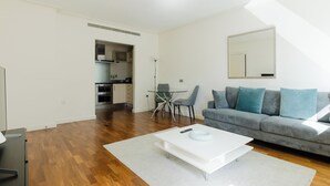 Uma sala de estar moderna com sofá, mesa de centro e área de jantar com cadeiras.