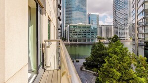 Um edifício alto com vista para um rio e outros edifícios modernos.