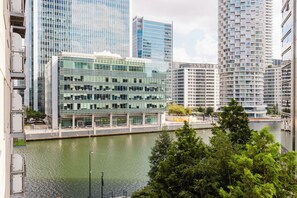Ein modernes Gebäude mit Glasfassade, Blick auf das Wasser und einem Fluss im Vordergrund.