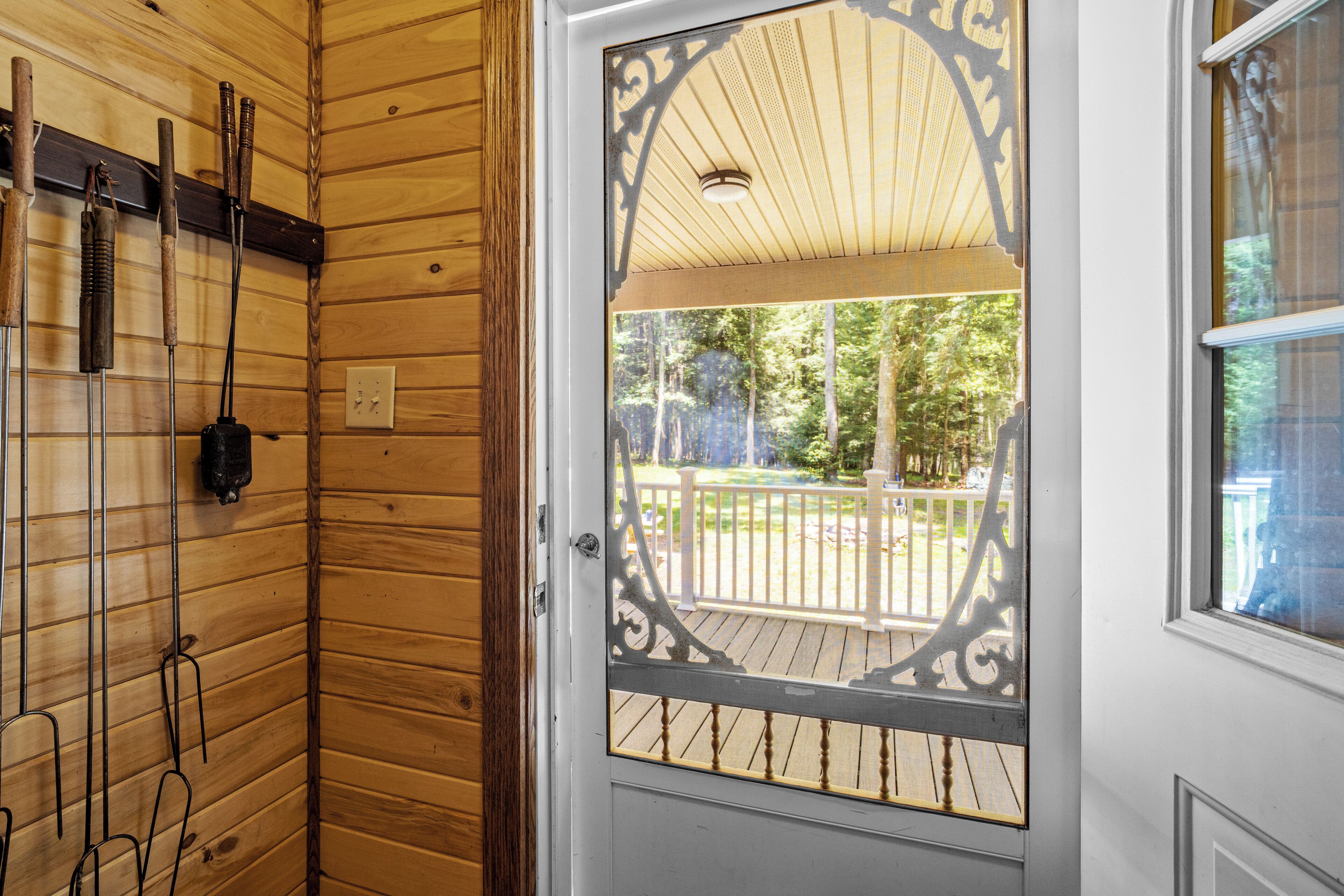 Un intérieur en bois avec une porte donnant sur une terrasse extérieure.