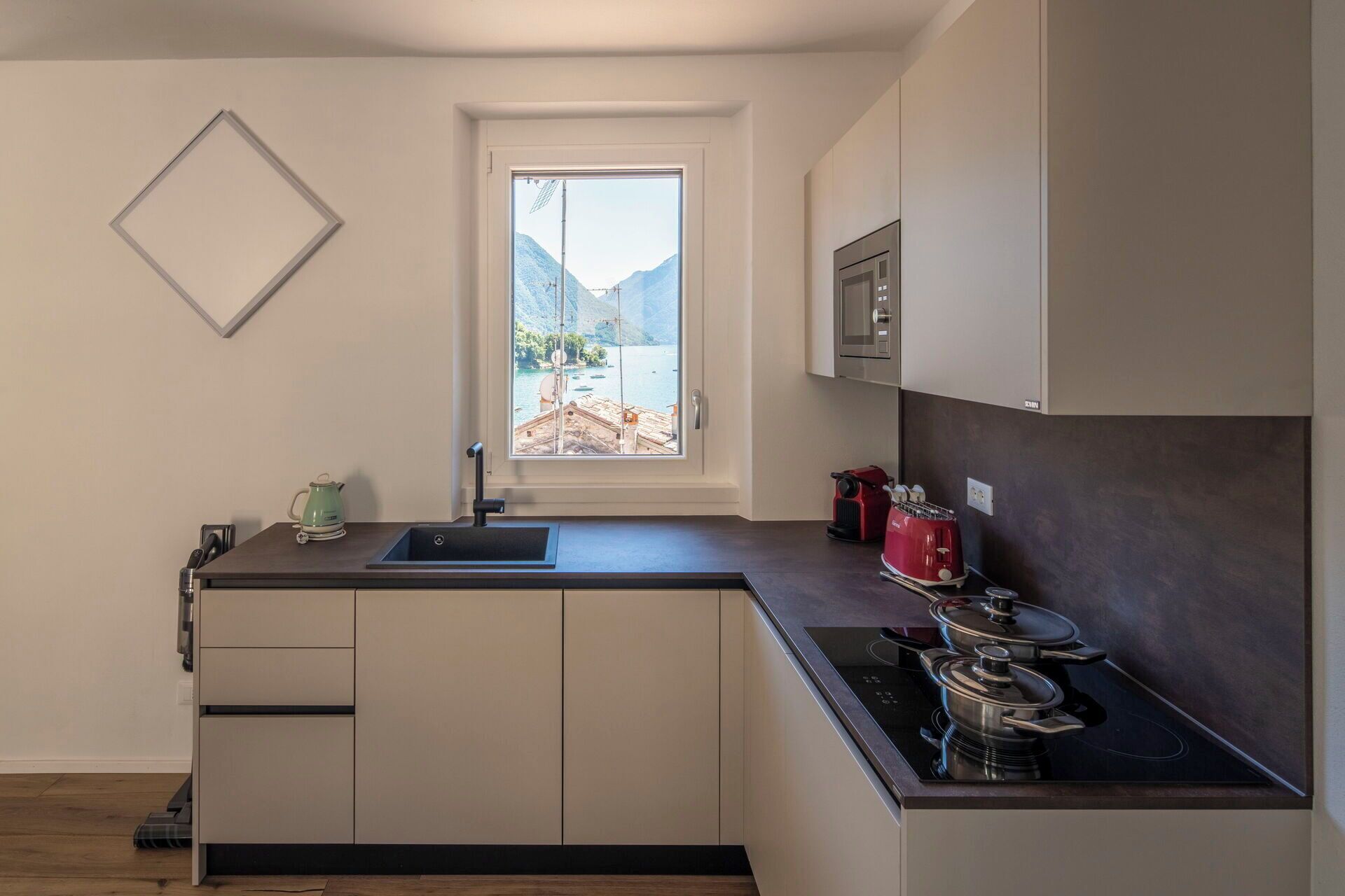 Una cocina moderna con ventana, un fregadero, estufa y armarios.