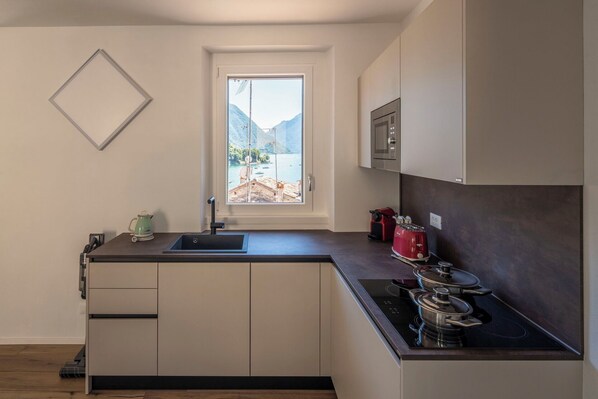 A modern kitchen with a window, a sink, a stove, and cabinets.