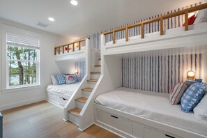 A bunk bed room with a staircase, a window with blinds, and a view of trees. - NEW! 30A Home! Dock, Golf Cart, Putting Green, Community Pool & 4 Bikes (Santa Rosa Beach)