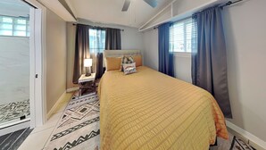 A hotel room with a bed, a nightstand, a lamp, and a patterned rug. - Al & Sherry's Oasis | Pet-Friendly Dream! (Rockport)