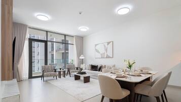 Una sala de estar moderna con comedor, ventanas amplias y vista a un edificio.