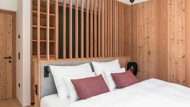 Ein Schlafzimmer mit einem Bett, einem Holzkopfteil und einem Kleiderschrank.