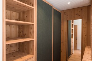 A wooden interior with built-in shelves and a dark wall panel. - Sunnseit Luxury Apartment with Lake View, Balcony, and Wi-Fi (Pracupola)