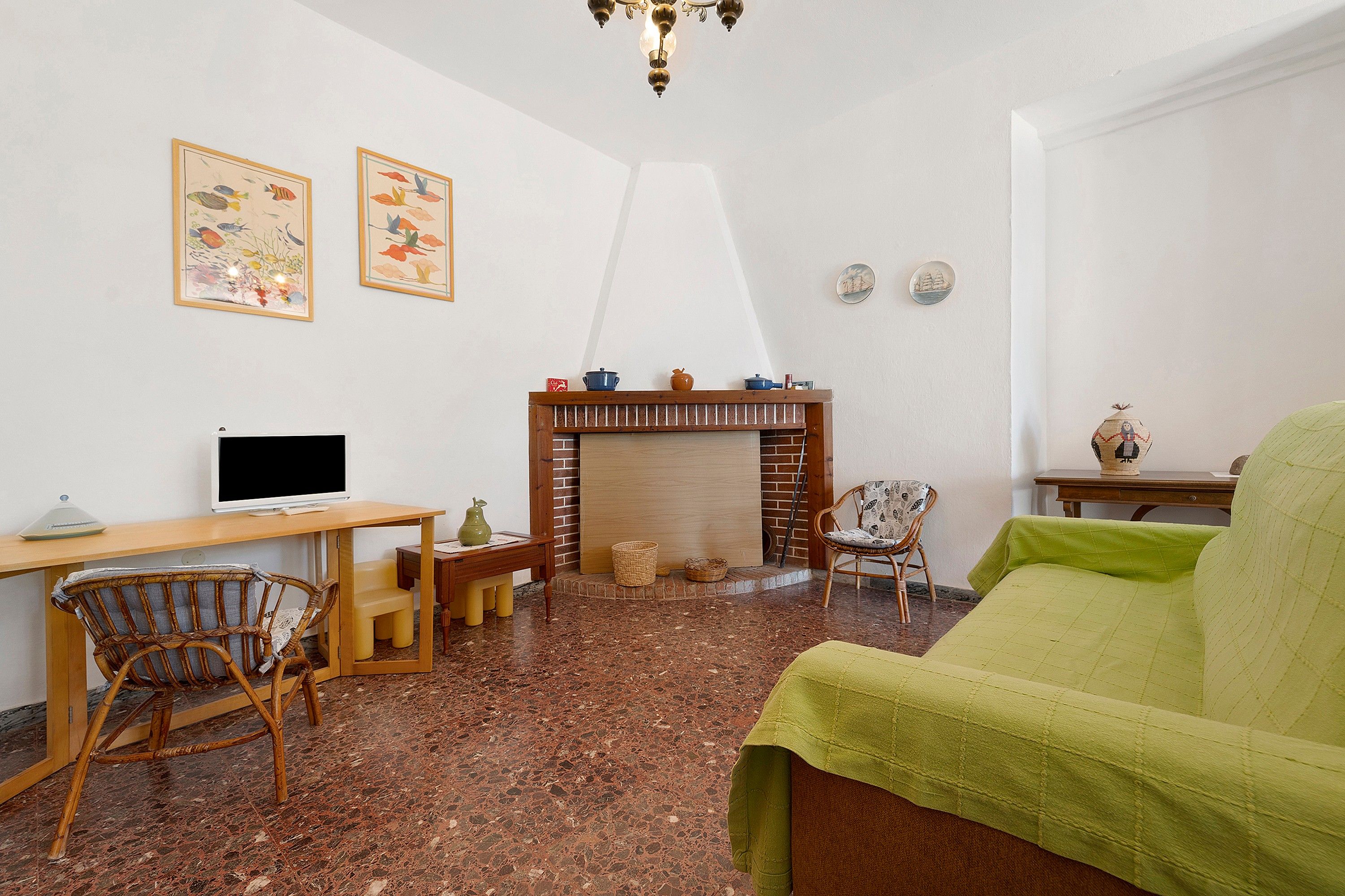 Un salon chaleureux avec une cheminée, un téléviseur et des fauteuils confortables.