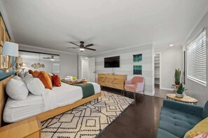 Un dormitorio moderno con cama, mesita de noche y ventilador de techo.