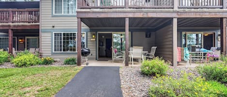 A two-story building with a covered patio, a pathway leading to the entrance, and a small garden area.