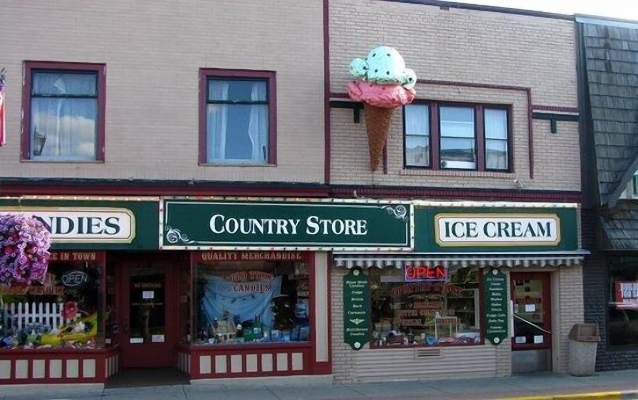 Edifici amb botigues que tenen les façanes indicades com a 'Country Store', 'Dolços' i 'Gelats'.