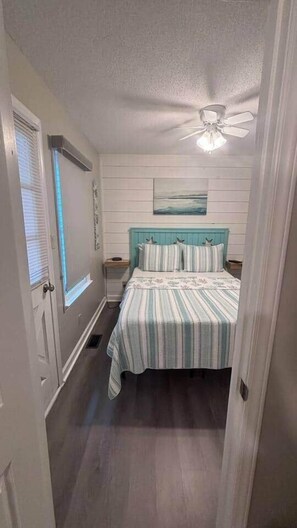 A bedroom with a bed, a ceiling fan, a window with blinds, and a painting on the wall. - 1495 Ocean Lakes Golf Cart ⛱️🏝️🩱🌊👙☀️🐚 (Myrtle Beach)