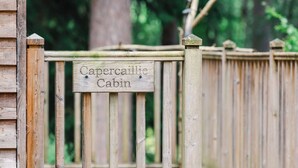 A wooden gate with a sign that reads 'Capercaillie Cabin.' - Cosy apartment for 4 people with TV, patio and pets allowed (Coldstone)