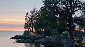 A coastal property with a stone pathway, trees, and a view of the sea.