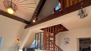 A spacious loft with a wooden staircase, a dining area, and a view of the sky through the sloped ceiling. - Le Chic Panoramique - Mountain and City Views - Villard de Lans (Villard-de-Lans)