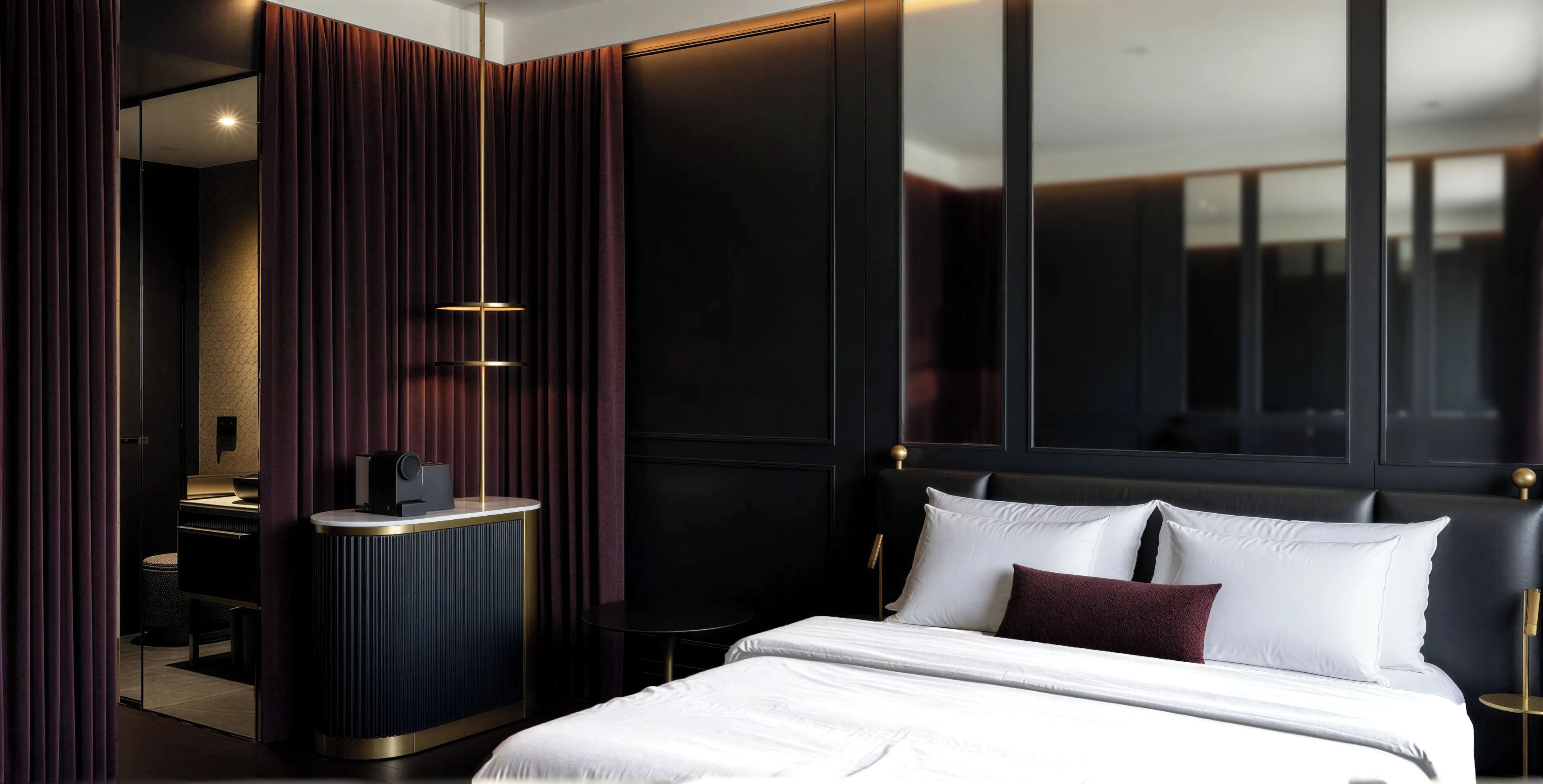 A modern hotel room with a large bed, a desk, and a mirror.