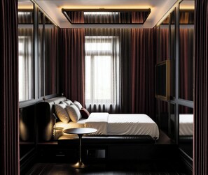 A modern hotel room with a large bed, a bedside table, a flat-screen TV, and a view of the city through the window. - The Love by Pytloun Hotels - Adults Only (Prague)