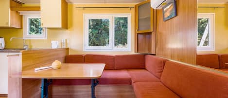 A compact kitchenette with a sink, a small table, and a window.