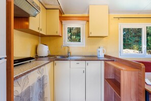 A compact kitchen with a window, a sink, and a coffee maker.