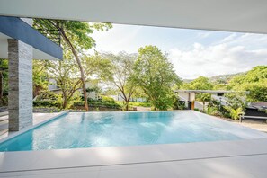 Une piscine offrant une vue sur la verdure environnante et les bâtiments.