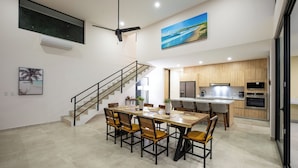 Una cucina moderna con mobili in legno, forno integrato e zona pranzo con tavolo e sedie in legno.