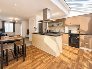 A modern kitchen with a central island, built-in appliances, and a skylight. - Modern 3BDR Family House in North Stifford (North Stifford)