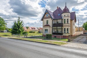 A two-story building with a gabled roof and a balcony on the second floor. - Maisonette Apartment "Villa Mary" in Lychen – 2 Bedrooms, Family-Friendly, Parking (Lychen)