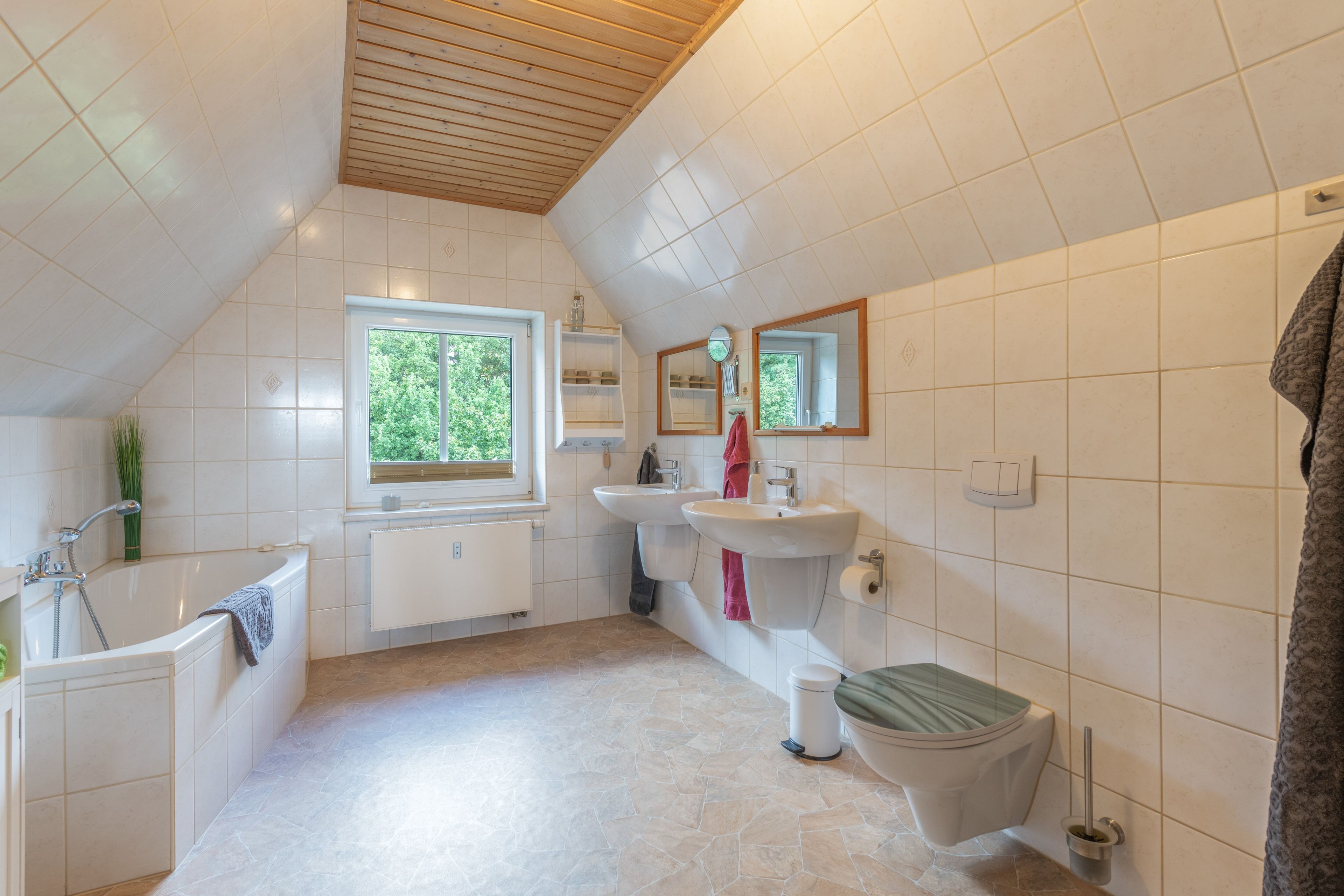 Un baño con bañera, lavamanos, inodoro y ventana.
