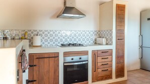 Eine Küche mit Herd, Backofen und einem hohen Schrank.